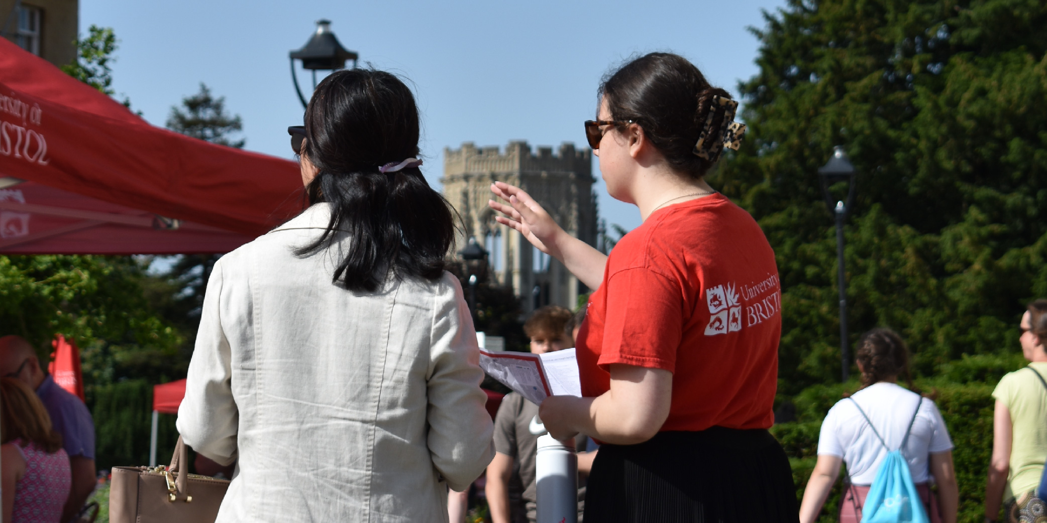 A student ambassador directing a prospective student, with Will's Memorial Building in the background.